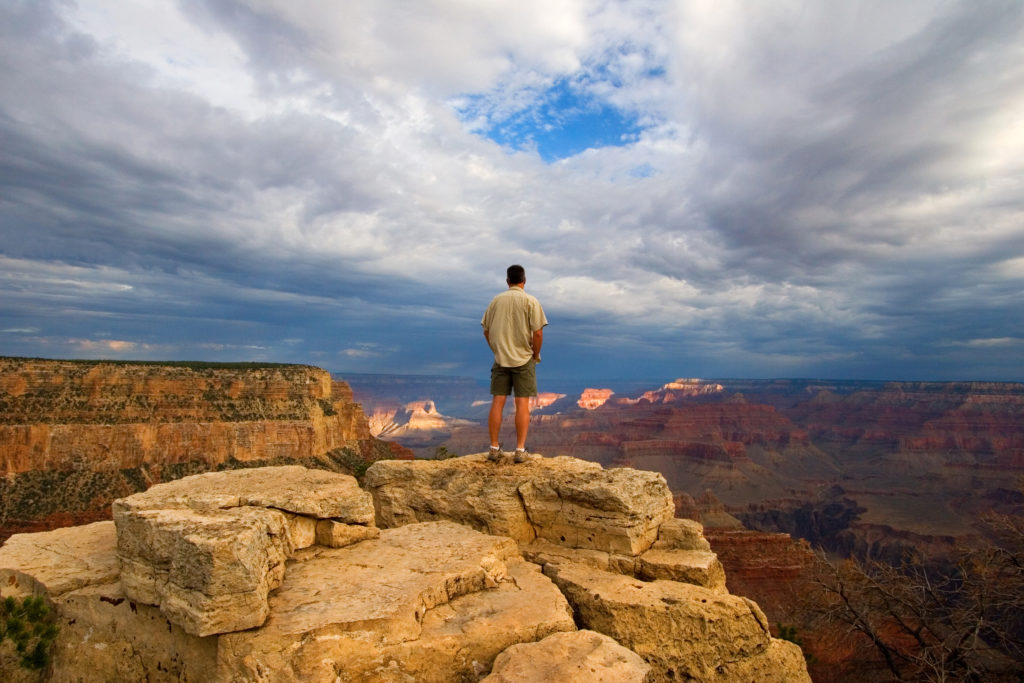 Hiker On Peak In Grand Canyon